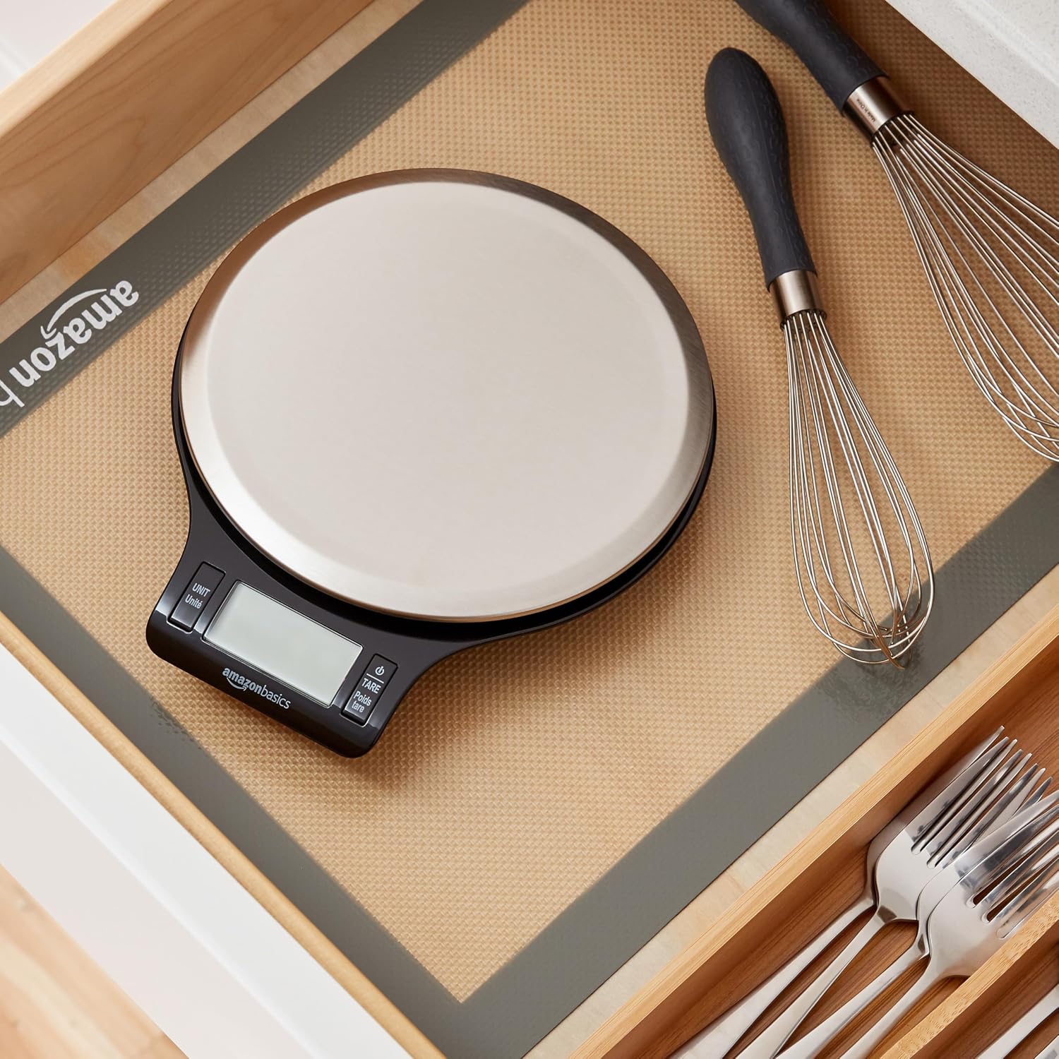 Báscula de cocina Amazon Basics guardada en un cajón junto a utensilios de cocina