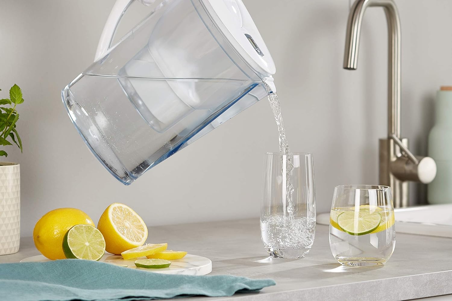 Jarra filtrante con cartucho Amazon Basics sirviendo agua filtrada en un vaso