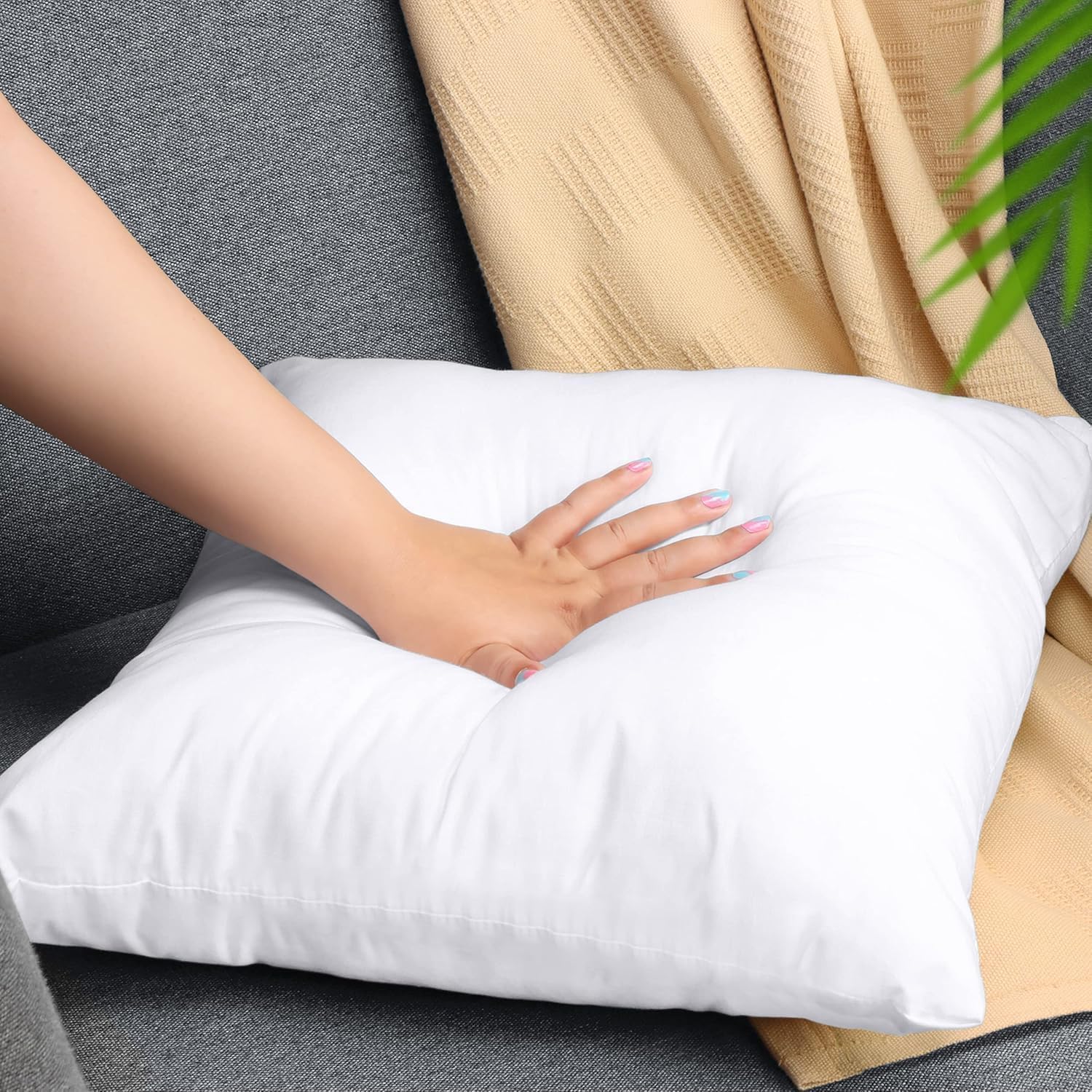 Mano presionando un relleno de cojín Utopia Bedding para mostrar su mullido